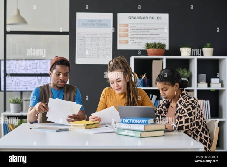 eleves en classe avec livres et ordinateurs