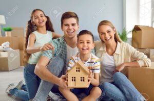 famille heureuse devant maison neuve lumineuse