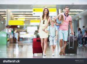 famille souriante avec valises et cheques vacances