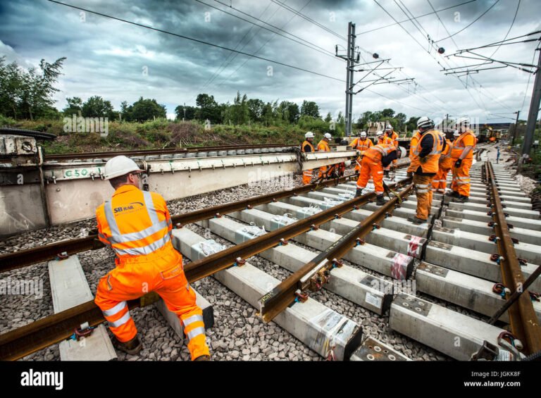 ouvrier posant rails sur voie ferree moderne