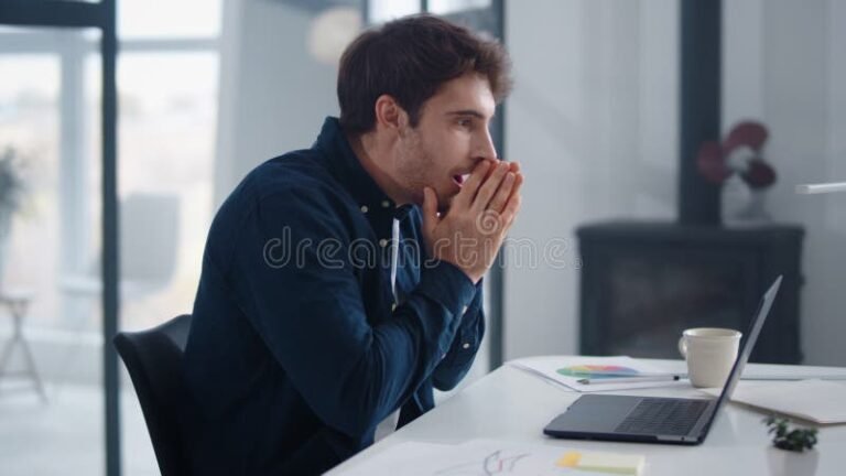personne reflechissant avec documents et ordinateur