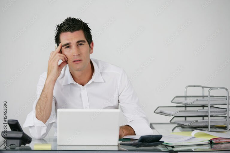 un homme pensif devant un bureau