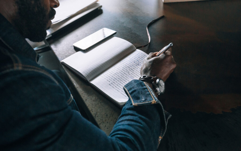 une personne ecrivant une lettre avec concentration